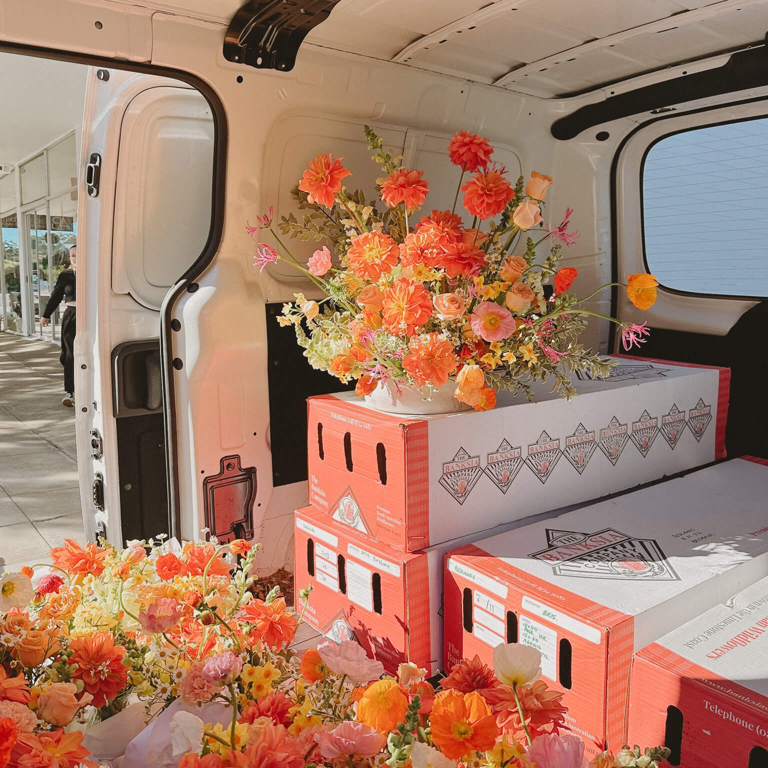 Bright florals stacked on boxes ready for delivery by Poppy Rose Brisbane