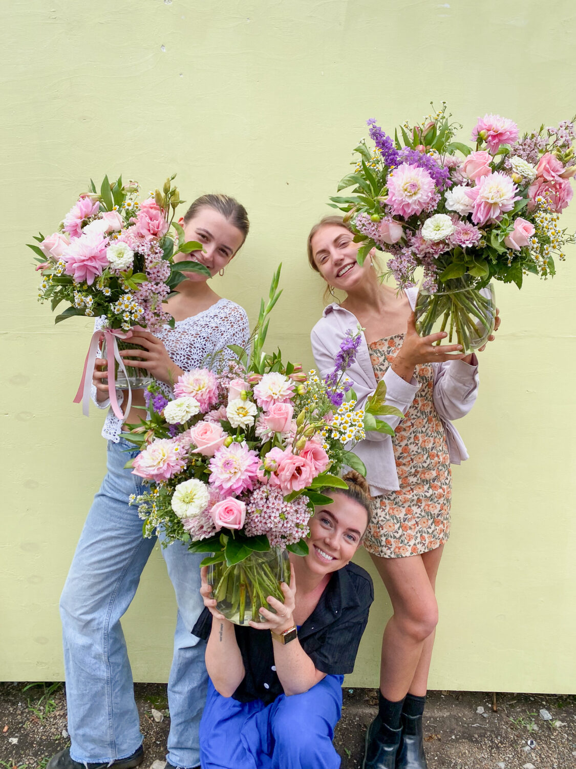 Three women holding beautiful flowers which are available for delivery in Brisbane